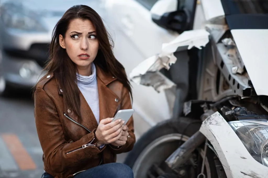 terrified using mobile phone and dialing for emergency service after a car crash in the city